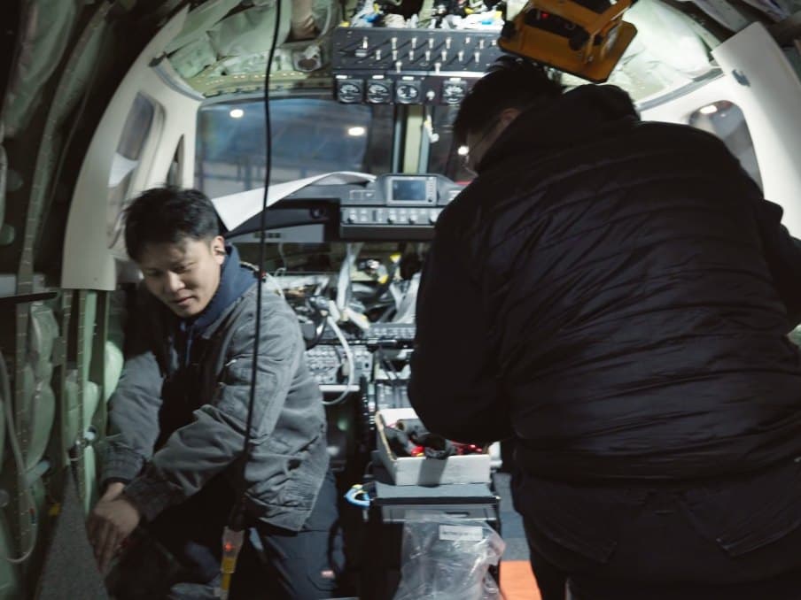 IAS technicians working inside an aircraft cockpit during an avionics installation