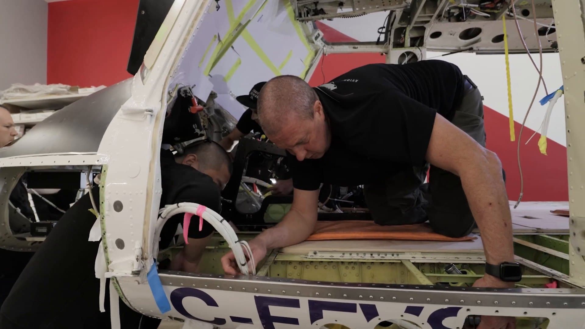 IAS technician routing new wiring through a Bell 412 cabin during a complete rewire