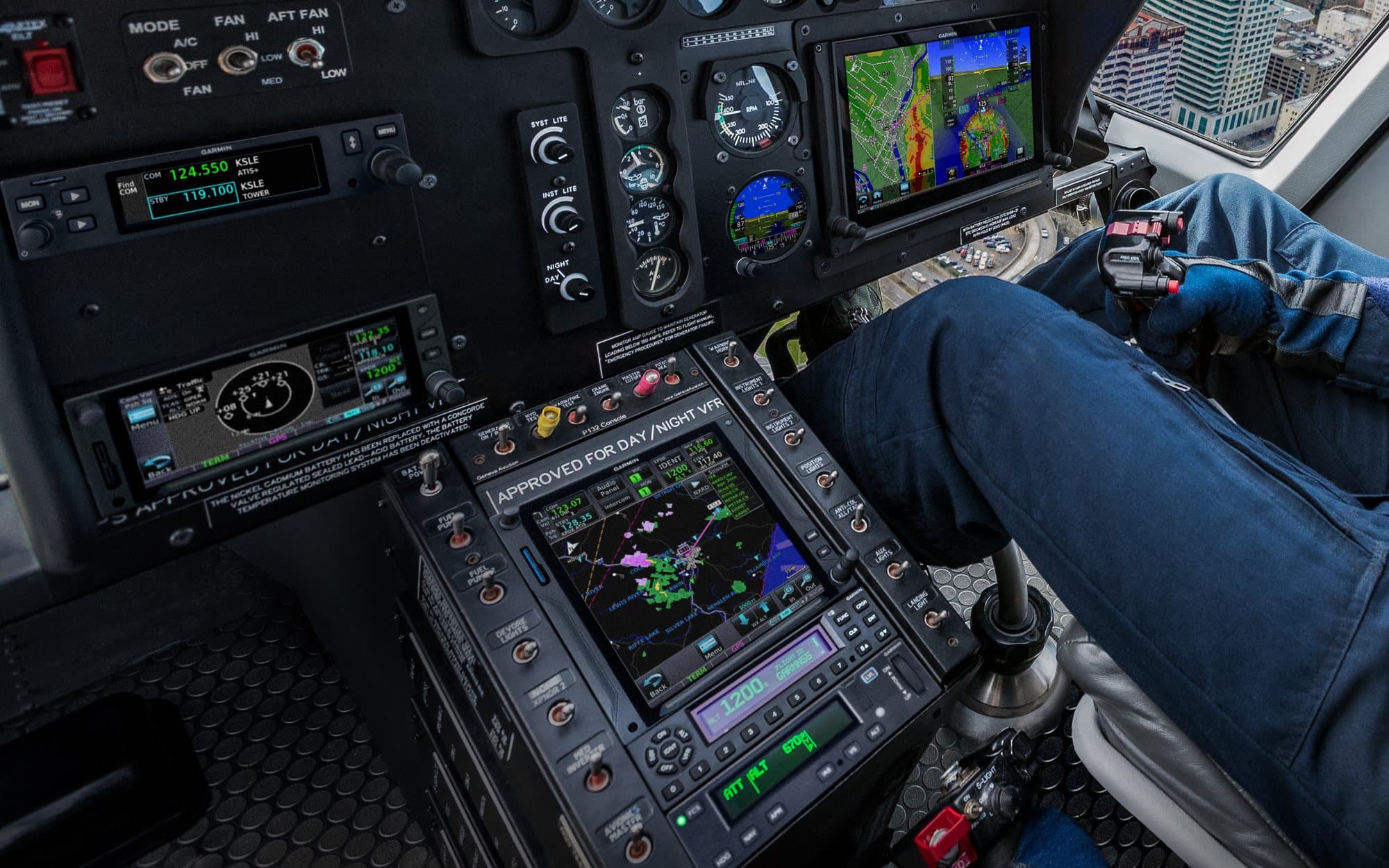 Garmin navigator and transponders showing ADS-B traffic and weather in a helicopter cockpit