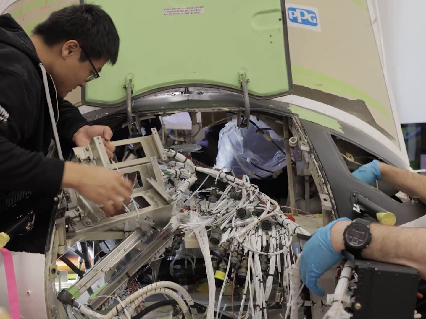 IAS apprentice and technician installing a new wiring harness during a Bell 412 rewire