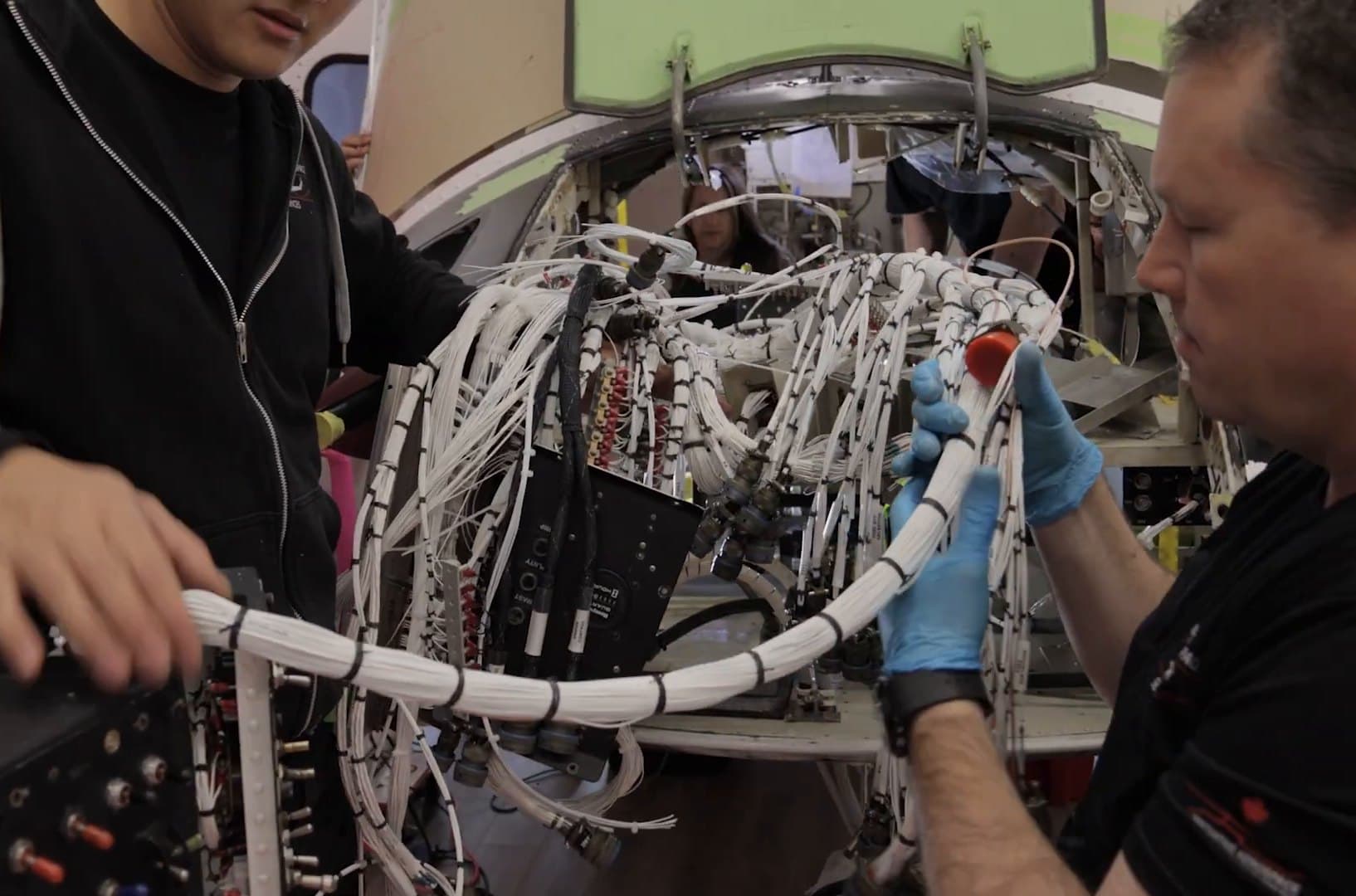 IAS technicians routing a newly built wiring harness through a Bell 412