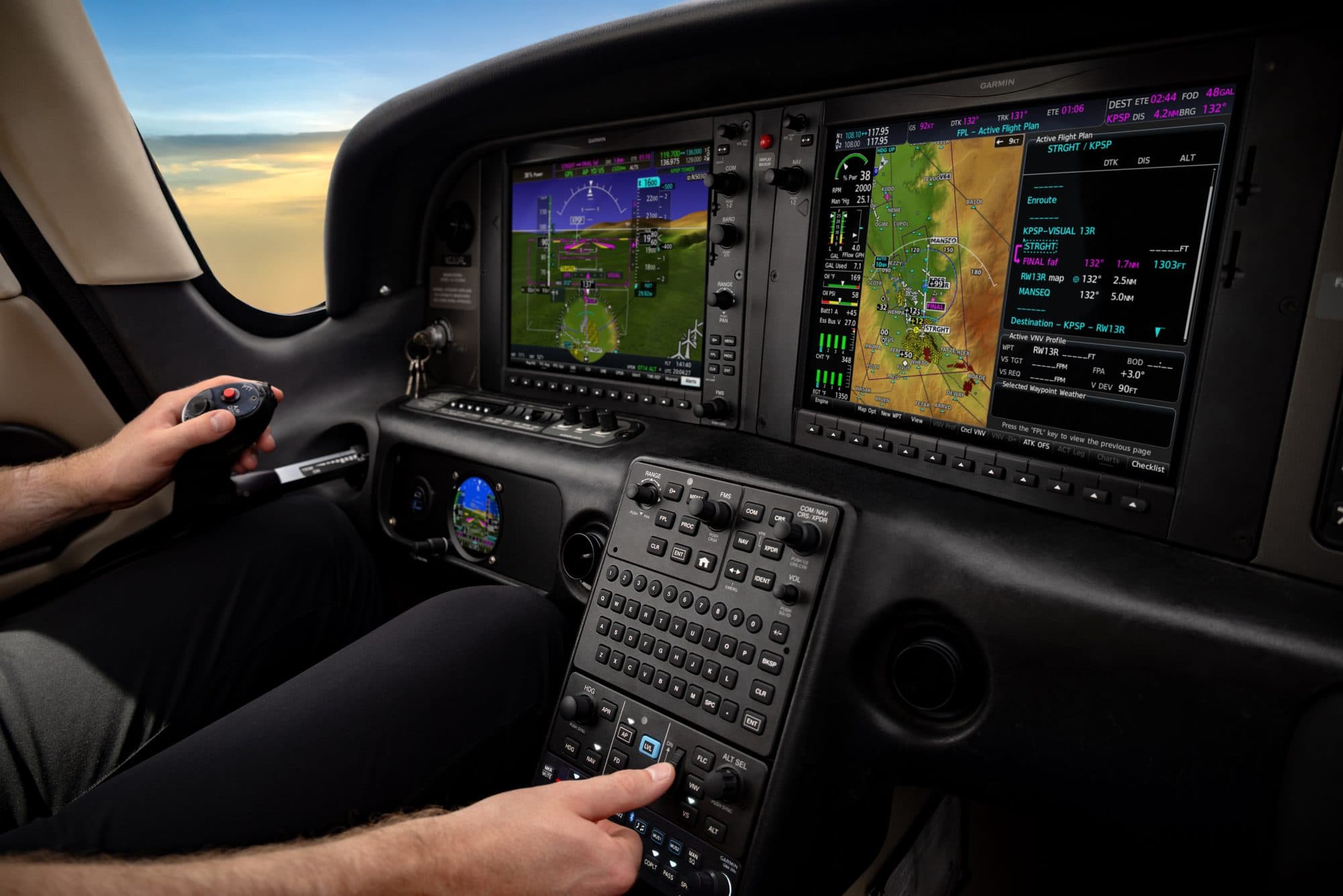 Pilot using a Garmin glass-cockpit flight deck and keypad