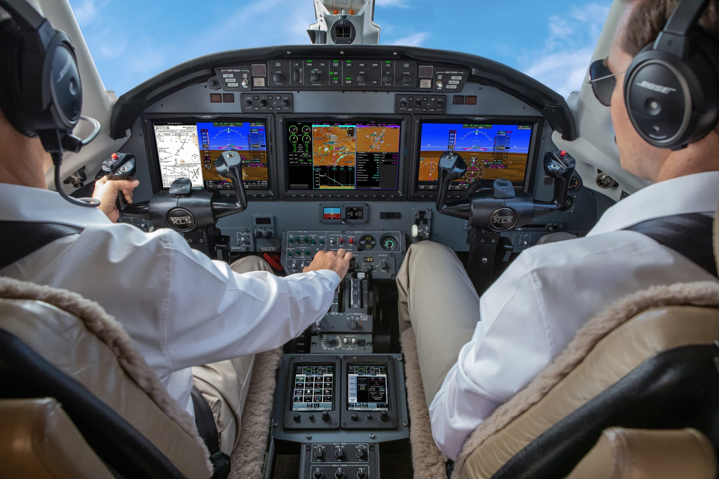 Flight crew in a jet cockpit fitted with Garmin avionics